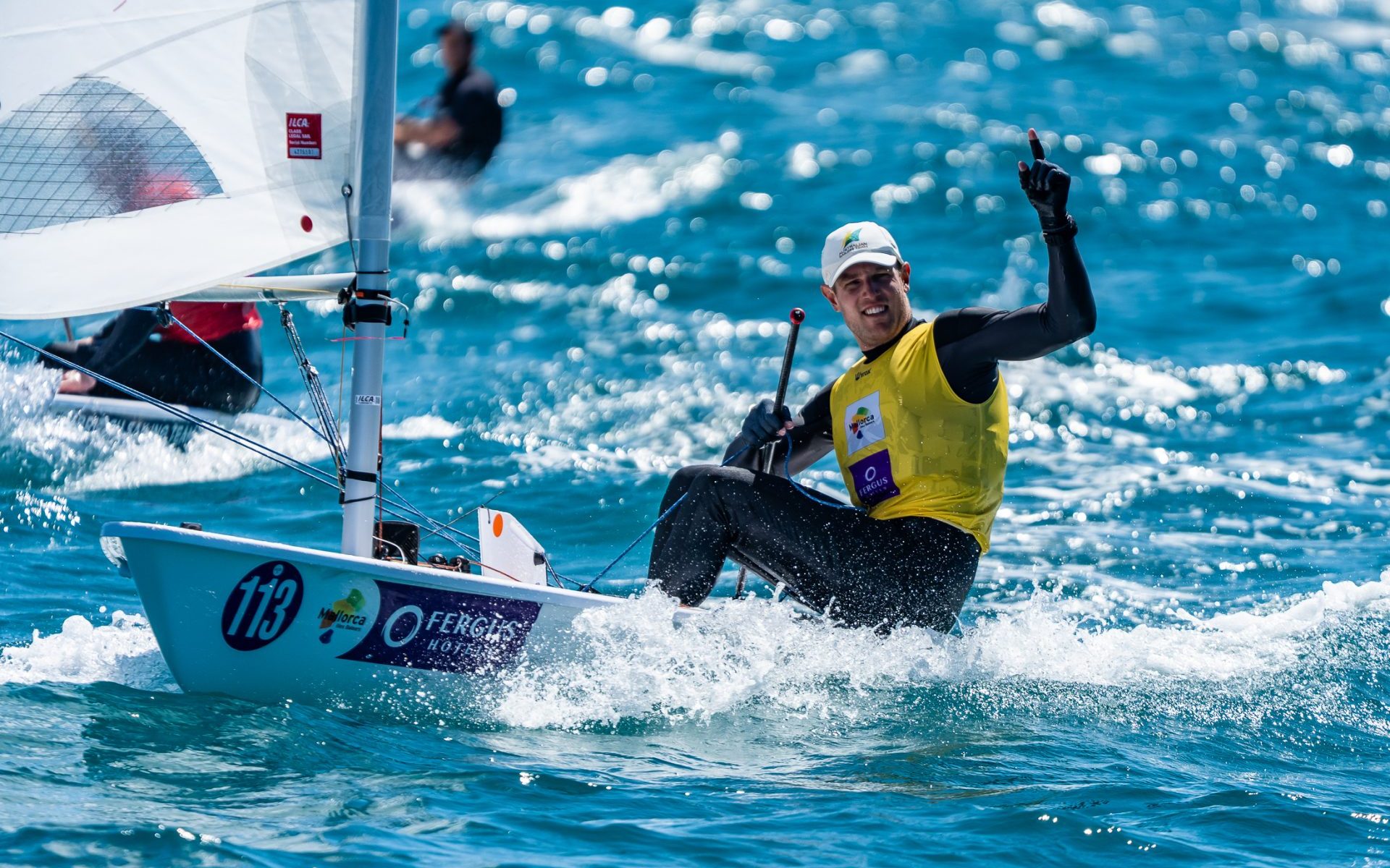 Australian ILCA 7 sailor Matt Wearn raises his finger in celebration aboard his dinghy after winning in Palma, Mallorca.